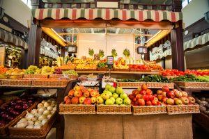 A fruit stand with baskets of fruit Description automatically generated