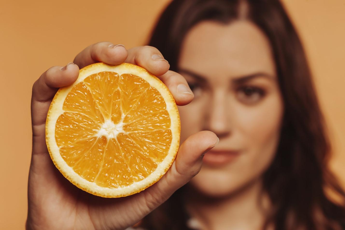 A person holding an orange Description automatically generated